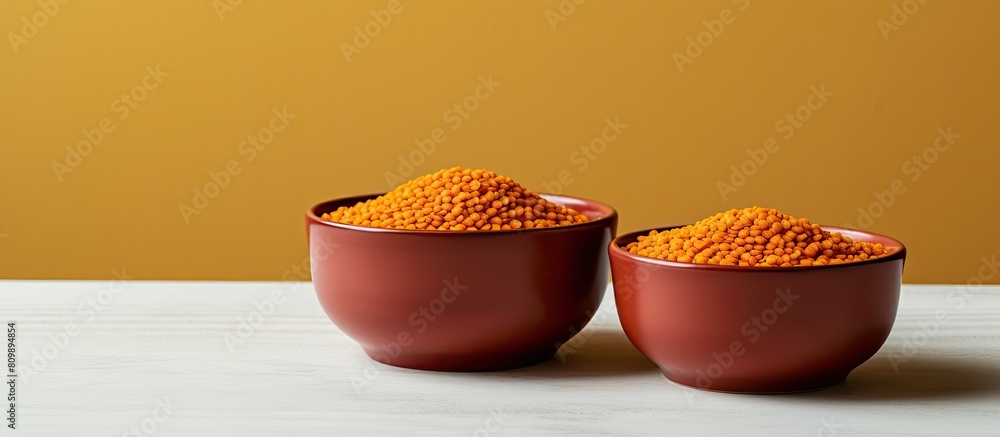 Aufkleber Bowls of dry uncooked red lentils are arranged on a table with a light colored background creating a copy space image