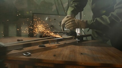 Craftsman in protective gloves and overall working with grinder at industrial plant, man grinding...