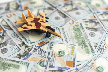 Background of one hundred dollar bills with model fighter airplane 