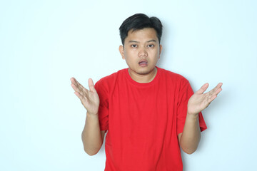 Young Asian man looks at the camera with a confused expression. Wearing red t-shirt