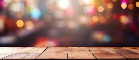 A brown wooden table with an empty surface is placed against a colorful blurred background suitable for showcasing products and creating website banners with copy space image