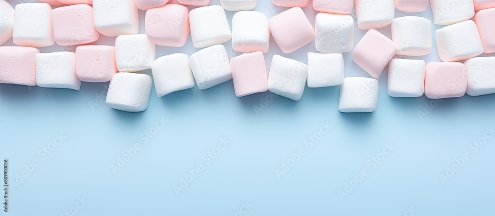 Aufkleber Marshmallows arranged in a flat lay composition with a copy space frame on a pastel pink and blue background Minimal yet creative concept