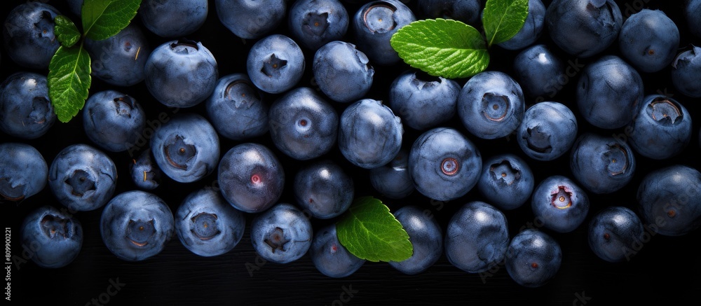 Poster A top down view of ripe organic blueberries arranged on a black background capturing the essence of summer berries The image features a flat layout with ample copy space