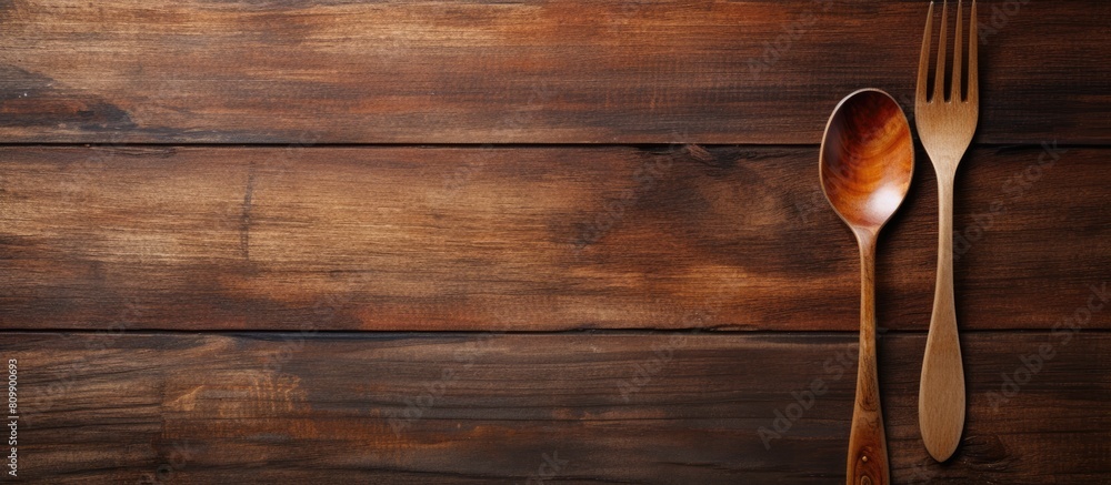 Poster A rustic wooden table with a pair of artisanal wooden spoon and fork on top leaving empty space for an image. Creative banner. Copyspace image