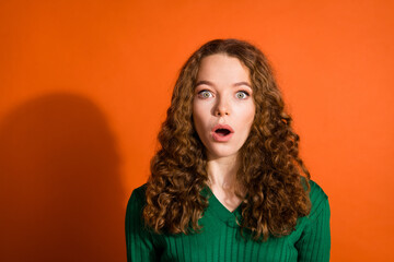 Photo of shoked ipmressed lady dressed green shirt open mouth big eyes isolated orange color...