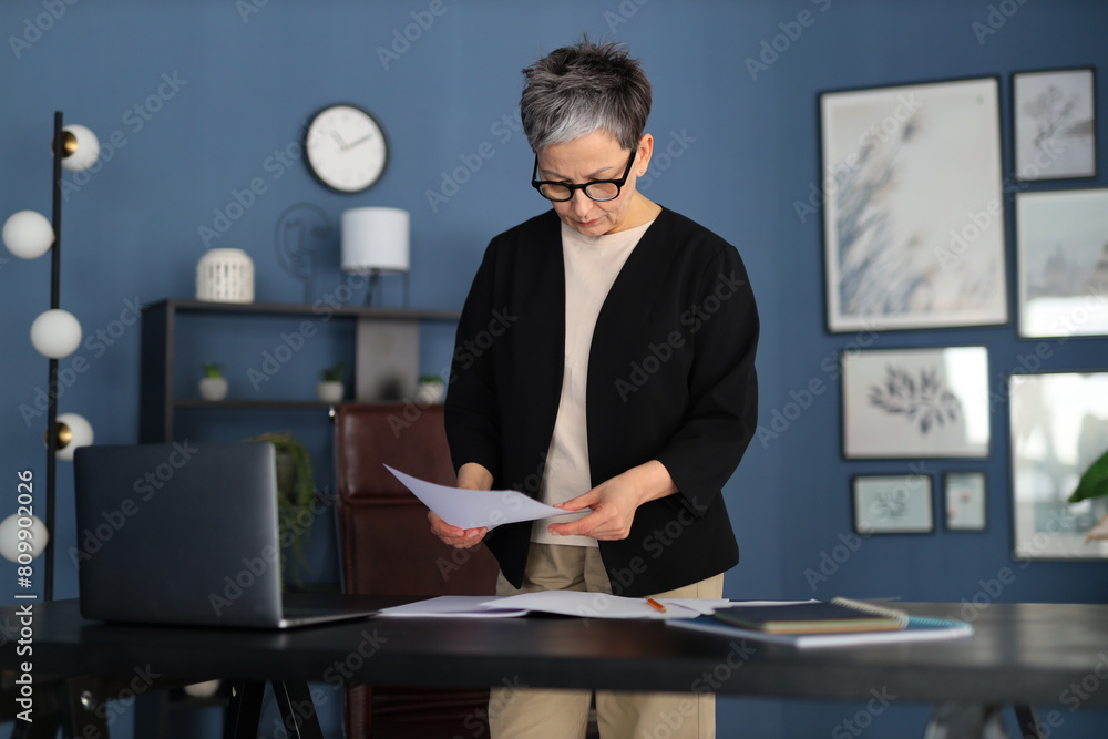 Sticker A businesswoman manages paperwork in a corporate office, embodying professionalism and confidence.