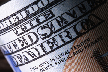 Macro image with description: THE UNITED STATE OF AMERICA on the one hundred US Dollar bill.