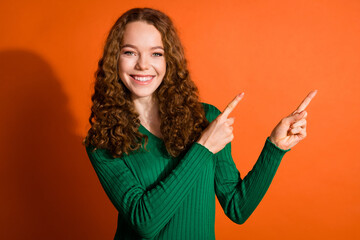 Photo of funky cheerful lady dressed green shirt showing two fingers emtpy space isolated orange...