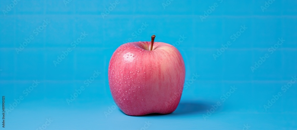 Poster a stunning pink apple is inside a box placed on a blue background leaving space for an image. creati