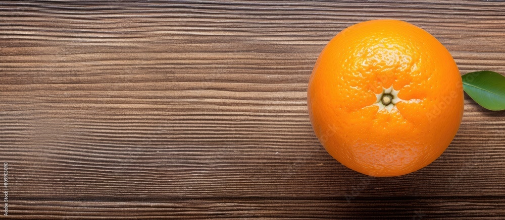 Poster Top view of a fresh orange placed on a textured wooden surface creating a visually appealing composition with copy space for an image