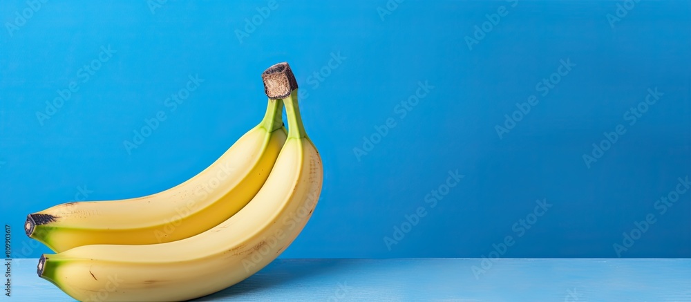 Aufkleber Studio shot of a banana on a blue background with copy space image