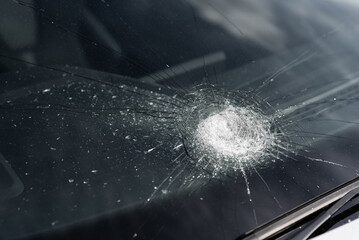 Close-up of a broken windshield on a car. Cracks in the glass