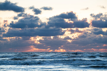 Beautiful sunset at the beach. With some flying seagulls. And rays of sunlight