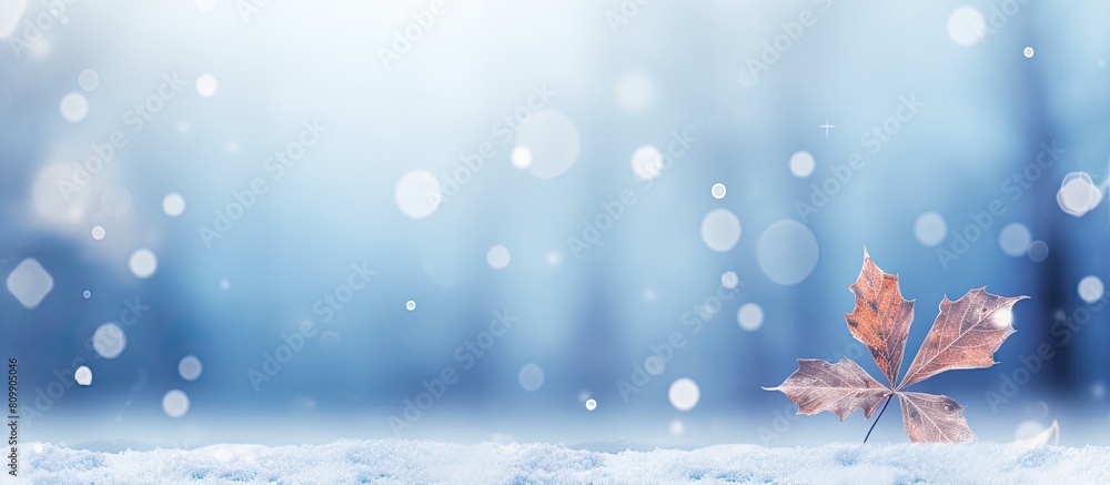 Wall mural Abstract blurred snowy winter background with glowing leaf backdrop and snowflakes perfect for copy space image