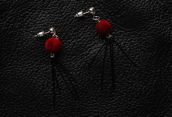 Stylish stud earrings on black leather background