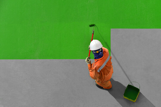 Crew man is painting ship's deck by green.