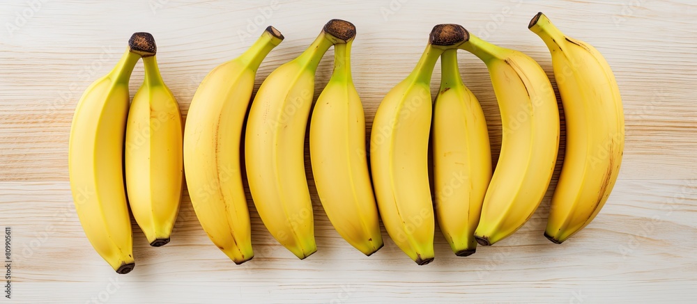 Fototapete A top view of three ripe bananas placed on a light wooden background leaving empty space for additional images or text