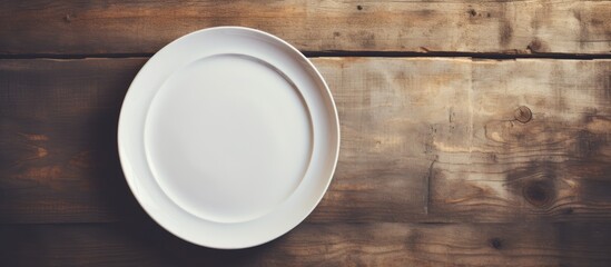 A vintage toned copy space image of a white plate resting on a napkin placed on a wooden tabletop against a grunge wall