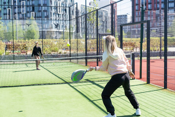 mother and daughter playing padel outdoor