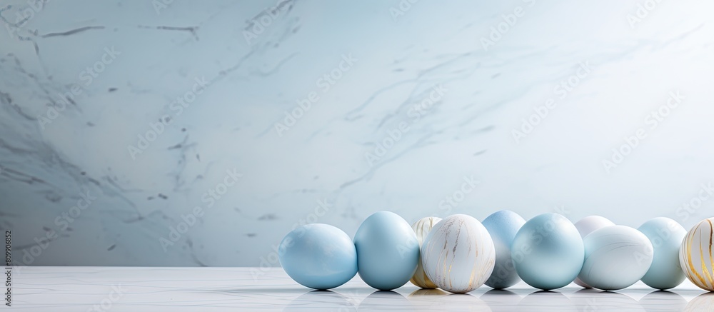 Poster The Easter eggs are arranged on a white marble table and placed against a light blue background leaving room for text in the image. Creative banner. Copyspace image