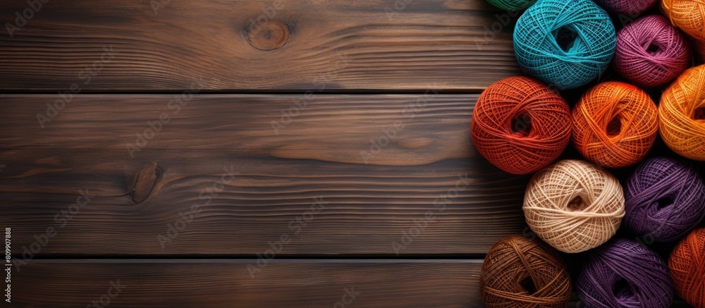 Aufkleber Top view of knitting threads on a wooden brown table with spokes The image offers copy space