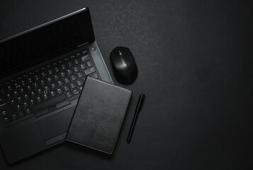 Laptop with notepad. Working space. Business concept. Black color trend. Flat lay