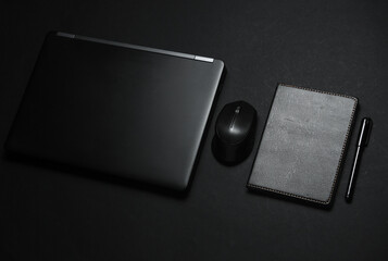 Laptop with notepad. Working space. Business concept. Black color trend. Flat lay