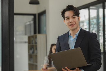 an employee is working in modern office and another coworkers are in the same room, working atmosphere in the office, businesspeople, work happily in the company