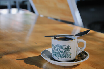 a cup of coffee on wood table, negative space for text