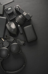 Naklejka premium Flat lay composition of Modern black gadgets and accessories on dark black background. Top view.