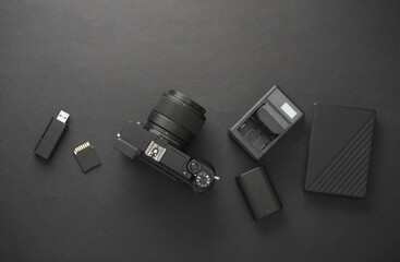 Modern equipment and accessories of a photographer on dark black background. Flat lay