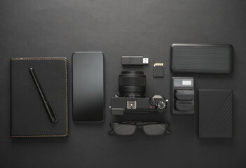 Modern equipment and accessories of a photographer on dark black background. Flat lay