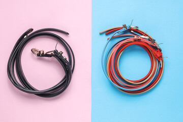Women's black and colored leather belts on a blue-pink background. Fashion accessories. Flat lay....
