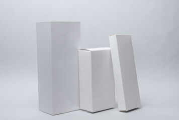 Different shapes of white cardboard boxes for presentation products on white background. Mockup for design.