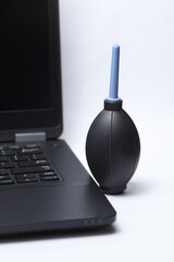 Laptop with cleaning enema on white background