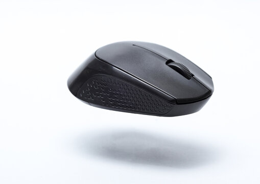 Black PC mouse floating on a white background