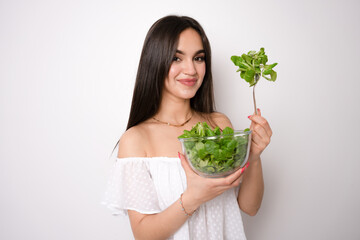 Young caucasian woman isolated on white background holding a bowl of salad with happy expression