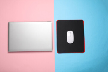 Laptop and PC mouse with PC mouse pad on pink blue background. Top view © splitov27