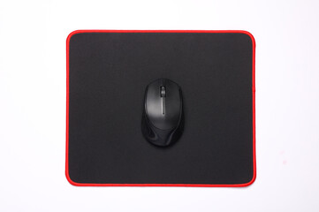 Black PC mouse with PC mouse pad on a black background