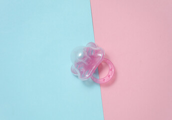 Baby pacifier on a blue pink background
