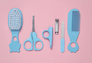 Baby care set on a blue-pink background. Scissors, comb, nail file and tweezers. Top view
