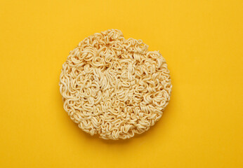 Dry instant noodles on yellow background. Top view