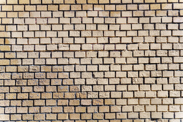 Beige brick wall with end-on bricks creating a textured pattern