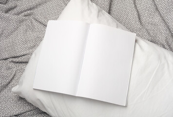 White blank magazine mockup on a blanket with pillow