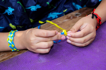 master class with children on making bracelets, weaving of different-colored stitches, hand-made...