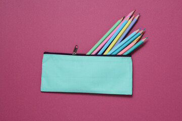 School pencil case with colored pencils on a pink background. Back to school concept