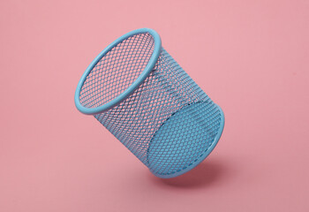 Blue Metal Basket for stationery floating on a pink background