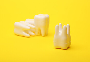 Plastic models of teeth on a yellow background