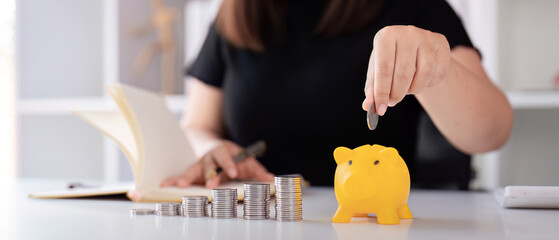 Woman hand putting coins in a piggy bank for save money and saving money concept