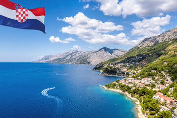 Croatian flag against coastline with Brela town and Adriatic sea in Makarska riviera, Dalmatia,...